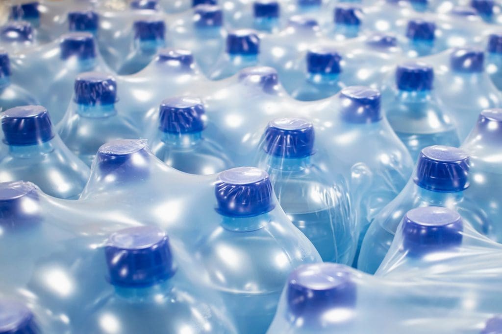 A close-up of plastic water bottles within shrink-wrapped cases