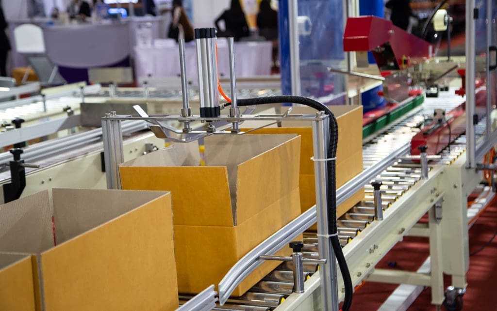 Brown cardboard boxes on a conveyor belt to be filled.