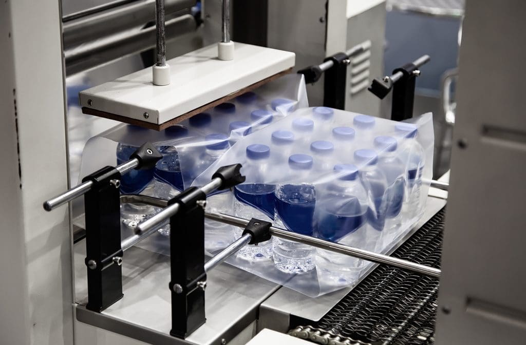 Bottled water being shrink-wrapped.