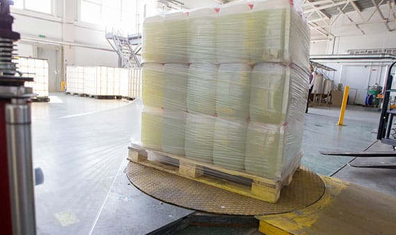 The machine for packing cellophane. Plastic jars wrapped in cellophane