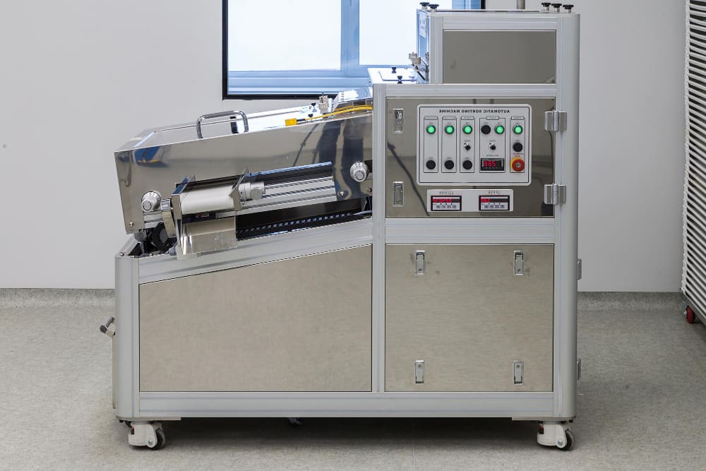 Automated industrial shrink band machine applying tamper-evident shrink bands on packaging containers in a high-speed production line
